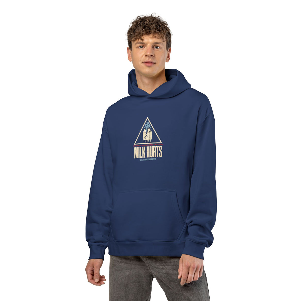 Man wearing the Unregulated Emissions Hoodie in cobalt, front: MILK HURTS warning triangle