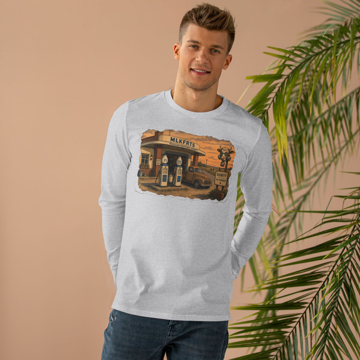 Man wearing the Peculiar Gas Station Long Sleeve Tee in Ash, gas station scene on the front