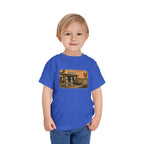 Toddler wearing the Peculiar Gas Station Toddler Tee in True Royal, gas station scene on the front