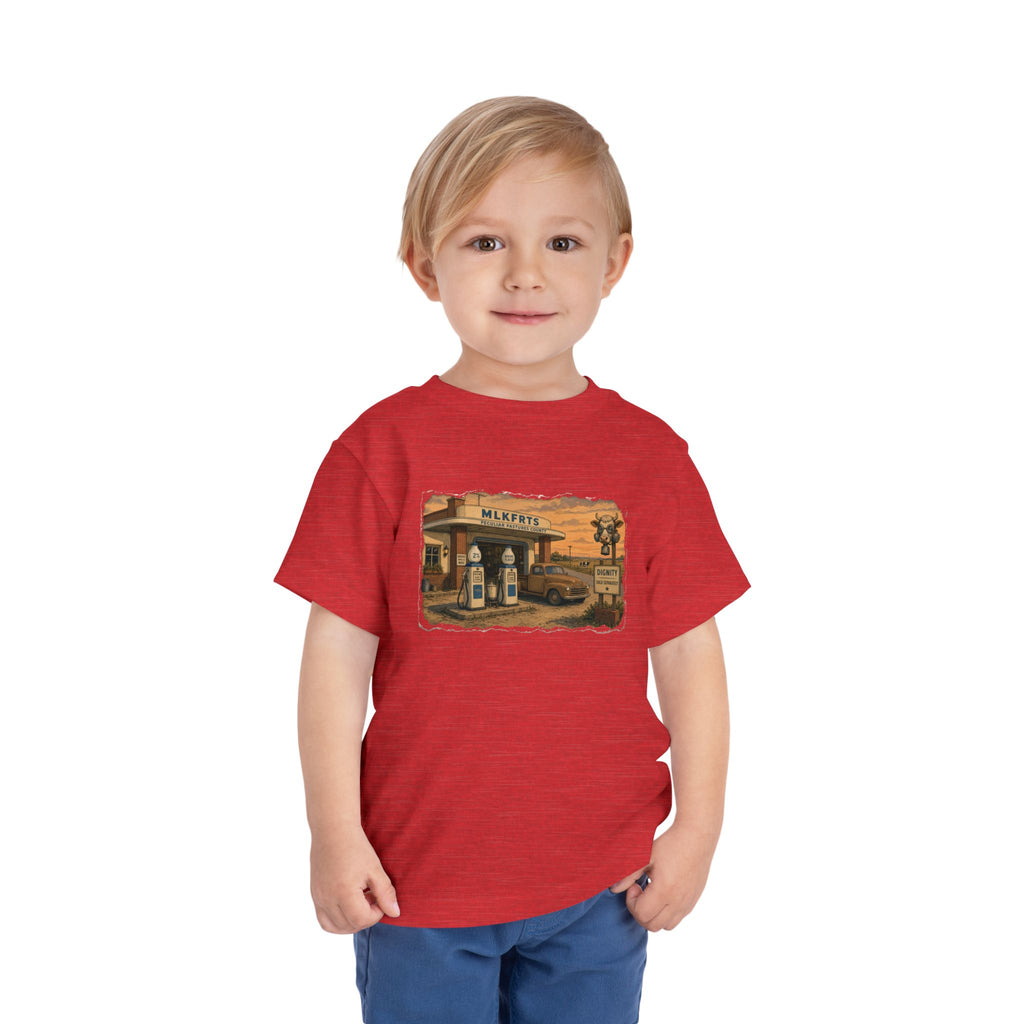 Toddler wearing the Peculiar Gas Station Toddler Tee in Heather Red, gas station scene on the front