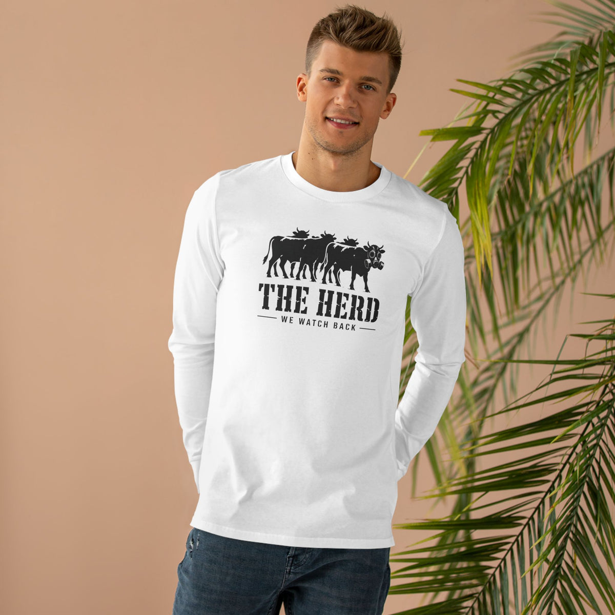Man wearing the Watch Back Long Sleeve Tee in white, front: cow lineup with one gas-mask cow, THE HERD, We Watch Back