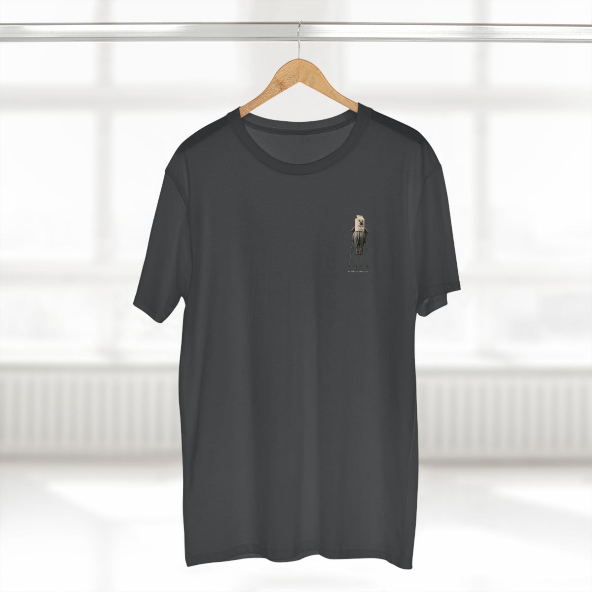 Stay Upwind Tee in charcoal on a hanger, front: small left-chest elephant