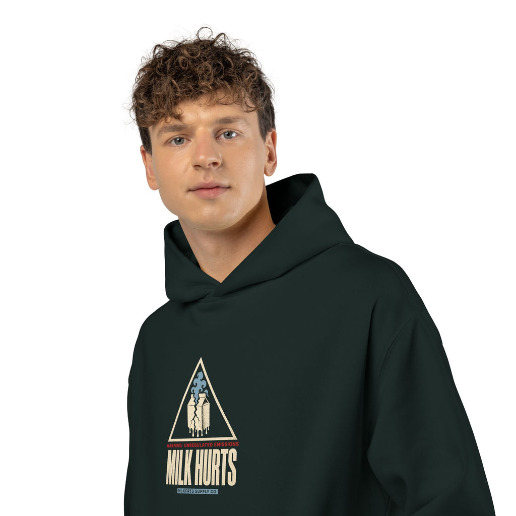 Man wearing the Unregulated Emissions Hoodie in pine green, front: MILK HURTS warning triangle