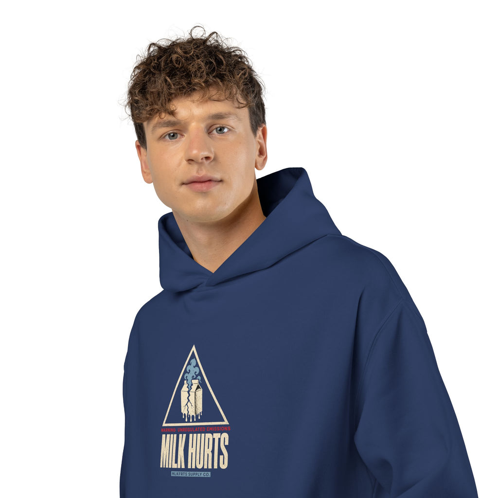 Close-up of a man wearing the Unregulated Emissions Hoodie in cobalt, front: MILK HURTS warning triangle