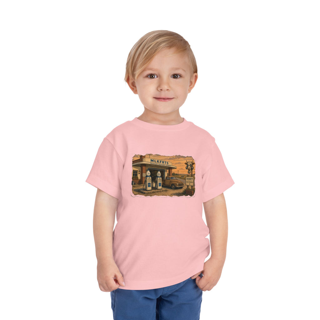 Toddler wearing the Peculiar Gas Station Toddler Tee in Pink, gas station scene on the front
