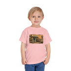 Toddler wearing the Peculiar Gas Station Toddler Tee in Pink, gas station scene on the front